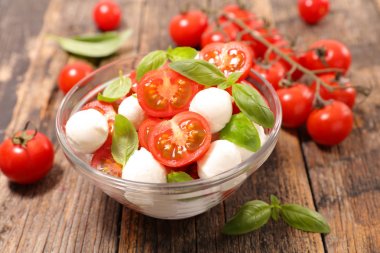 Top domates salatası mozzarella ve fesleğen ile tahta masada bırakır
