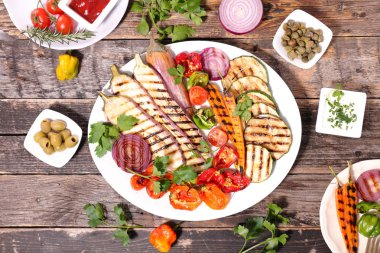 Kızarmış kabak, patlıcan, domates, soğan ve havuç beyaz tabakta