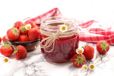 delicious strawberry jam in glass jar on marble table clipart