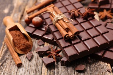 ahşap masa üzerinde tarçın kabuğu ile çikolata bar