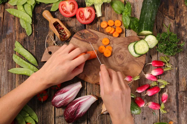 Menschenhände Schneiden Frische Möhren Auf Einem Holzschneidebrett Mit Frischem Gemüse — Stockfoto
