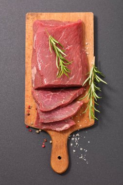 Ahşap doğrama tahtası üzerinde rosemary ile ham sığır eti