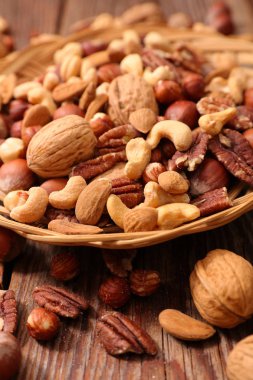 Ahşap masa üzerinde twiggen sepette karışık Kuruyemiş