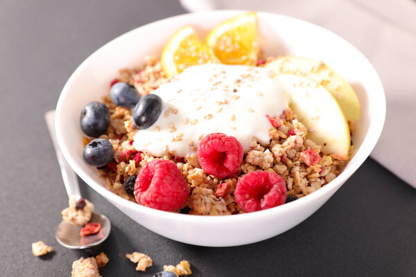 Granola with fresh berries and yogurt in bowl