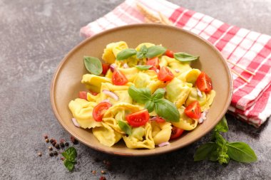 mantı makarna domates ve fesleğen taş zemin üzerine