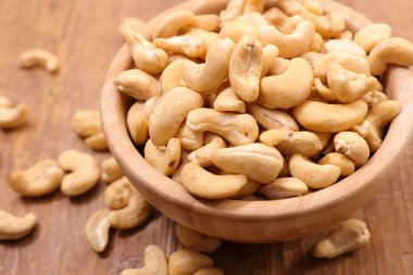 ahşap masa üzerinde bir kapta kaşu somun