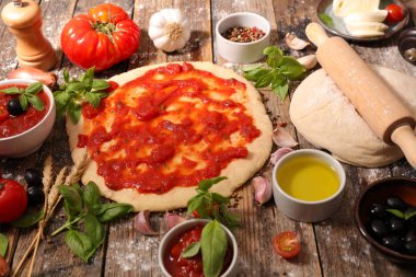 Çiğ pizza hamuru ve ahşap masa malzemeleri.