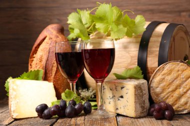 Kırmızı şarap, peynir ve ekmek ahşap masa üzerinde gözlük