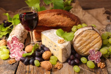 Kırmızı şarap, peynir ve ekmek ahşap masa üzerinde gözlük