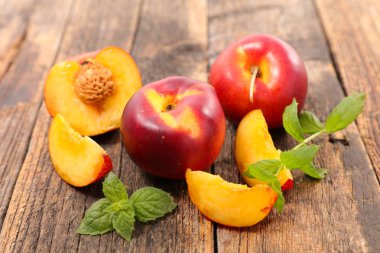 ahşap masa üzerine nane yaprakları ile taze şeftali