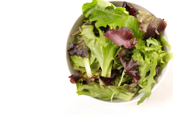 fresh lettuce leaves in bowl on white background