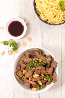 Fıstık ve ahşap masa Tabaklarda makarna ile lezzetli kızarmış Dana