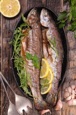 otlar ve ahşap masa üzerinde limon ile balık 
