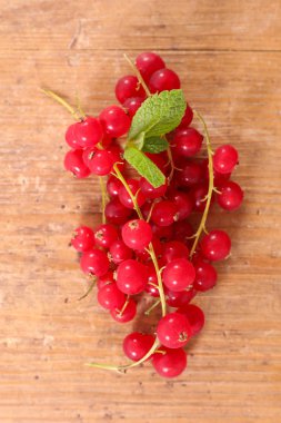 ahşap arka plan üzerinde olgun kırmızı kuş üzümü
