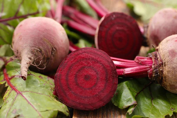 raw beetroots with leaves on wooden background