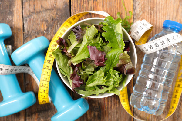 salad with dumbbell and water close up shot