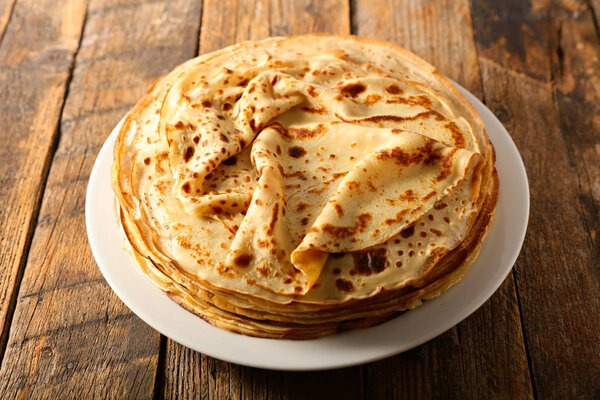 stack of crepes on wood background