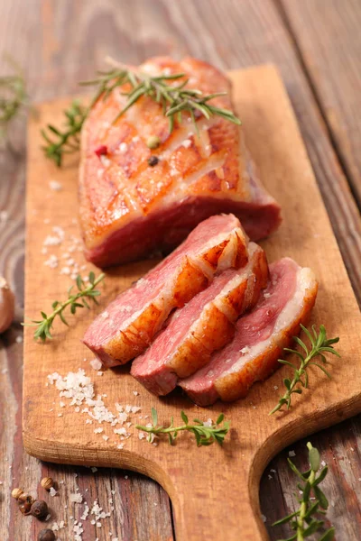 fried duck breast on wooden board