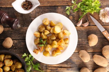 Ahşap arka planda otlu ızgara patates.