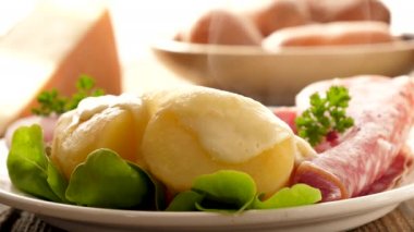 Jambon ve peynirli haşlanmış patatesin yakın çekim görüntüleri.