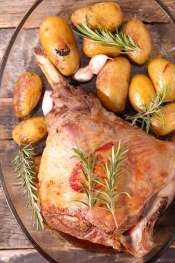 Kızarmış kuzu budu, patates ve biberiye.