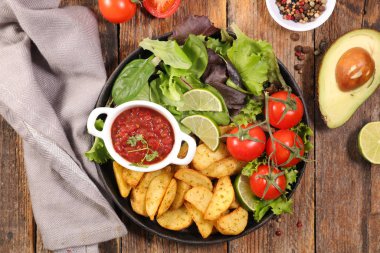 Kızarmış patates, domates sosu ve sebze salatası.