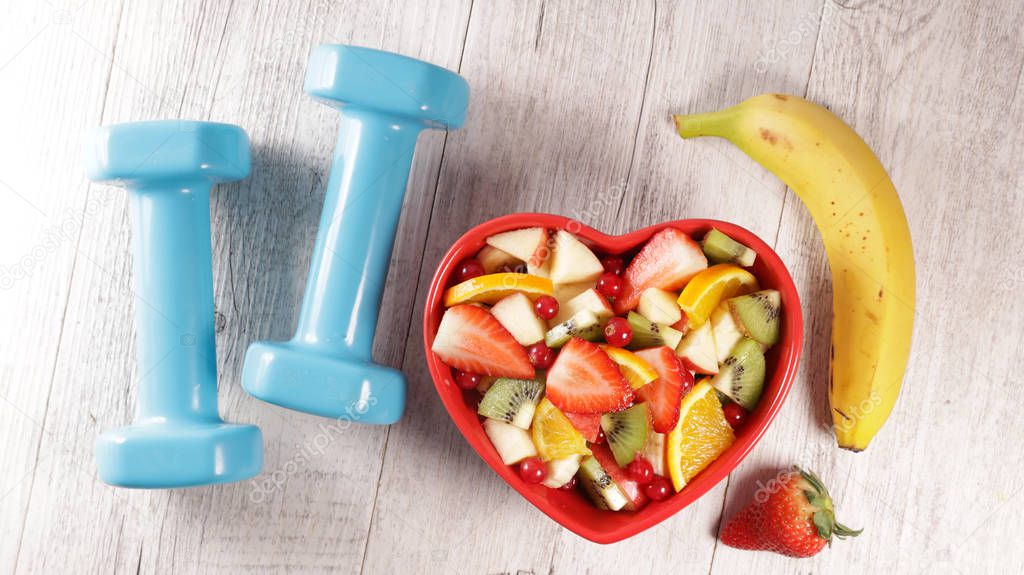 fruit salad and dumbbell- fit health food concept