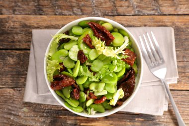 Kurutulmuş domatesli sebze salatası, marul ve bakla.