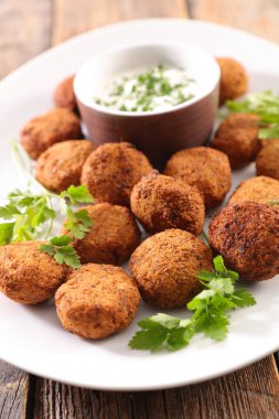 Sarımsaklı yoğurt ve bitki soslu falafel.