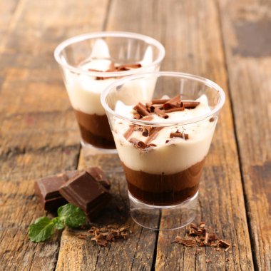 Tahta arka planda çikolata ve kremalı tatlı.