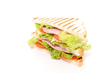 Beyaz arka planda marul, domates ve jambonlu ızgara tost.