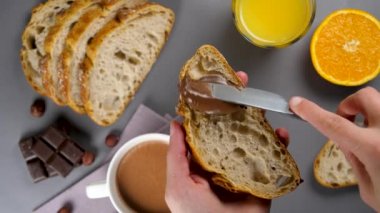 Kadın kahvaltı için bir dilim ekmek hazırlıyor