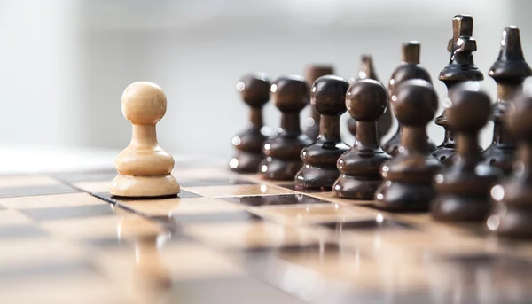Un peón permaneciendo contra el juego completo de piezas de ajedrez . — Foto de Stock