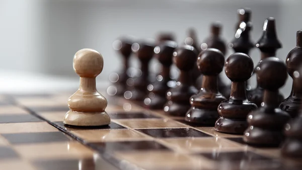 Een pion blijven tegen de volledige set van schaakstukken. — Stockfoto