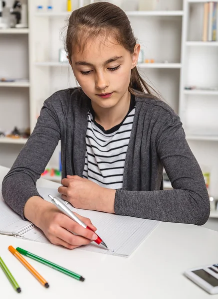 Mooi meisje op haar schoolproject thuis werken. — Stockfoto