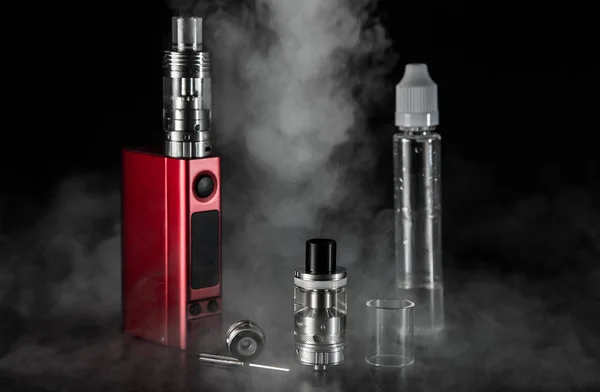 Vape e-vloeistof en vaping apparaat voor elektronische sigaret op een donkere achtergrond — Stockfoto
