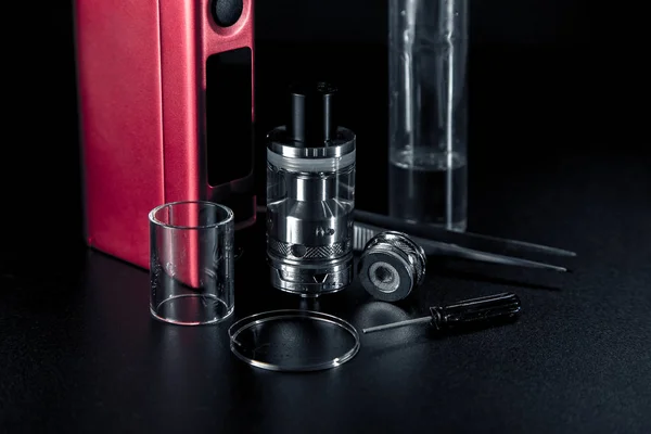 Vape e líquido e dispositivo de vaporização para cigarros electrónicos sobre fundo escuro — Fotografia de Stock