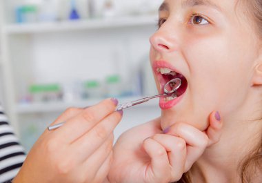 Küçük kızın ağzından dişlerini diş hekimi tarafından tedavi sırasında geniş açılış yakın çekim