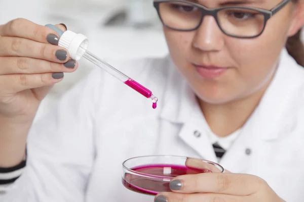 Una adolescente en un laboratorio escolar de química, haciendo experimentos en laboratorio . — Foto de Stock