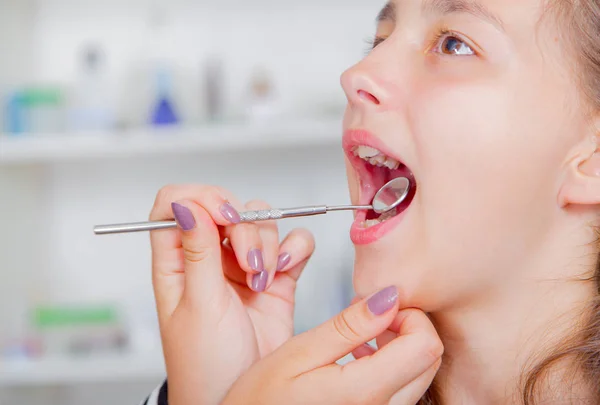 Gros plan de la petite fille ouvrant largement la bouche pendant le traitement de ses dents par le dentiste — Photo
