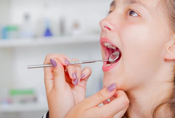 Close-up of little girl opening his mouth wide during treating her teeth by the dentist — Stock Photo, Image