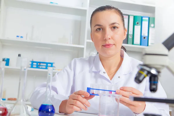 Jeune femme scientifique en laboratoire, faisant des expériences en laboratoire . — Photo