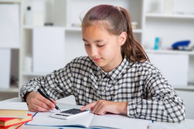 Genç kız sınavlarına hazırlanıyor. Genç kız okul için ödev.