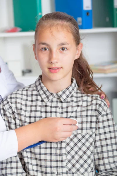 Médico feminino examinando adolescente com estetoscópio — Fotografia de Stock