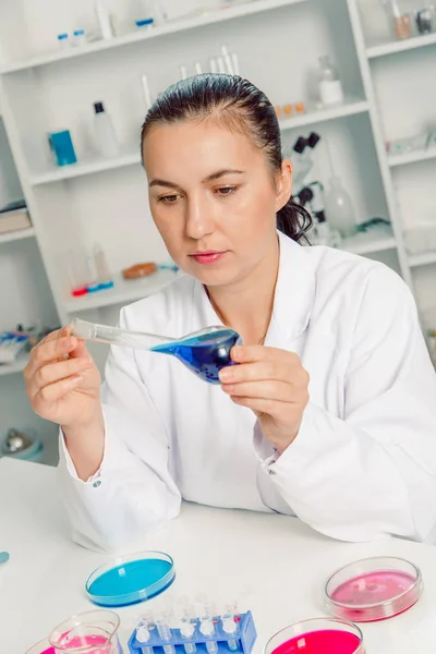 Unga kvinnliga forskare i labbet, gör experiment i labbet. — Stockfoto