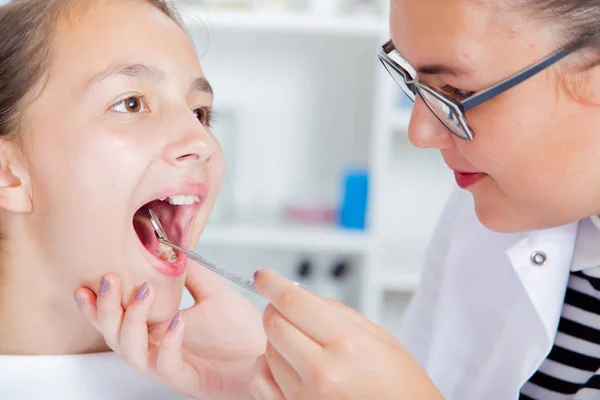 Крупный план маленькой девочки, широко раскрывающей рот во время лечения h — стоковое фото