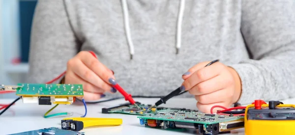 Schoolgirl  repairing the electronic printed circuit board.Computer repair