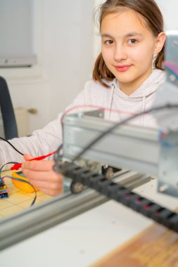 CNC makine üzerinde çalışan genç kız.