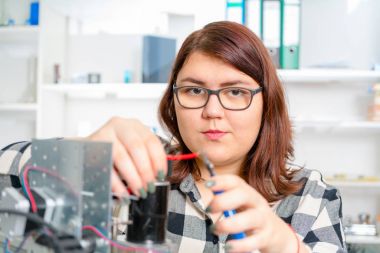 CNC makine üzerinde çalışan kadın çırak.