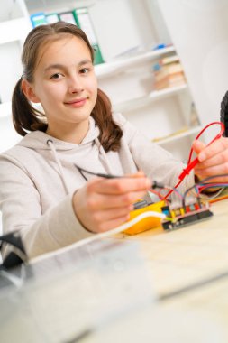 CNC makine üzerinde çalışan genç kız.